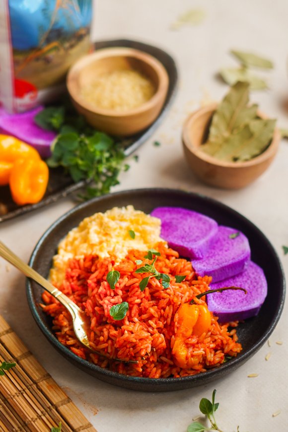 Jollof rijst met gekookte yam en roerei